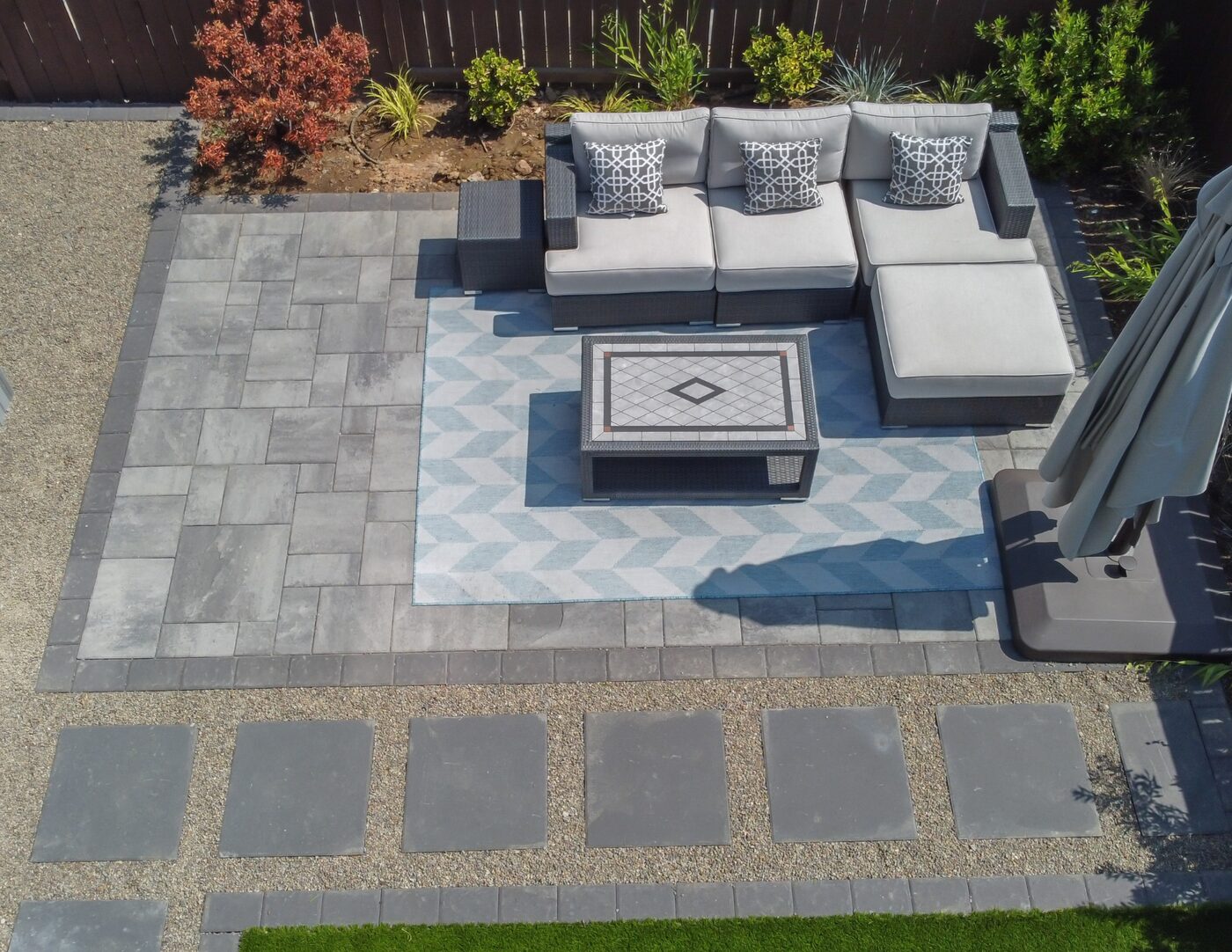 Aerial close view of a finished Ridgefield paver lounge with a fire table and stepping-stone path